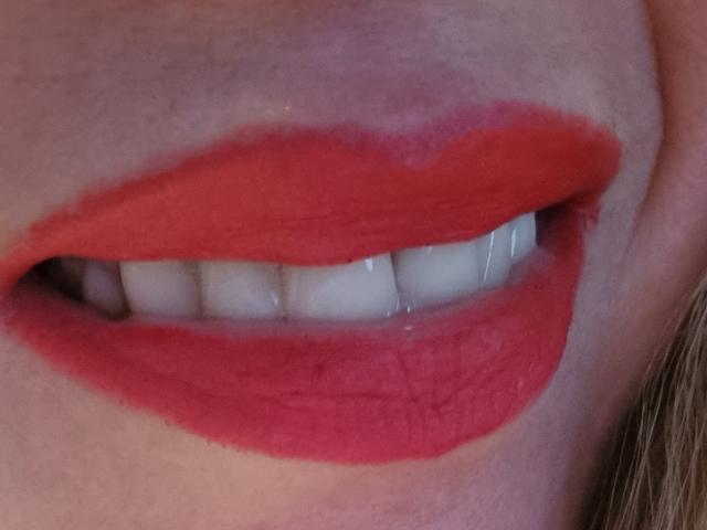Les lèvres rouges de Lolai69 sont légèrement entrouvertes, révélant ses dents blanches et brillantes. Sa peau est claire, et l'image est un gros plan qui se concentre sur ses lèvres et ses dents..