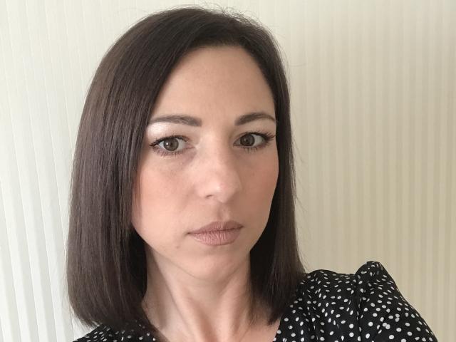 LadyBeautiful heeft rechtbruin haar, bruine ogen, subtiele make-up en draagt een zwart shirt met stippen en gerimpelde schouders. Haar uitdrukking is neutraal en ze heeft een kleine neus..