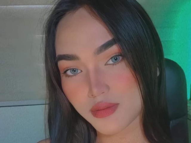 La princesa Kylie tiene el cabello castaño oscuro, ojos azules y lápiz labial rosa. Está mirando a la cámara con una ligera sonrisa, y lleva un piercing en la nariz. Sus cejas son gruesas y oscuras..