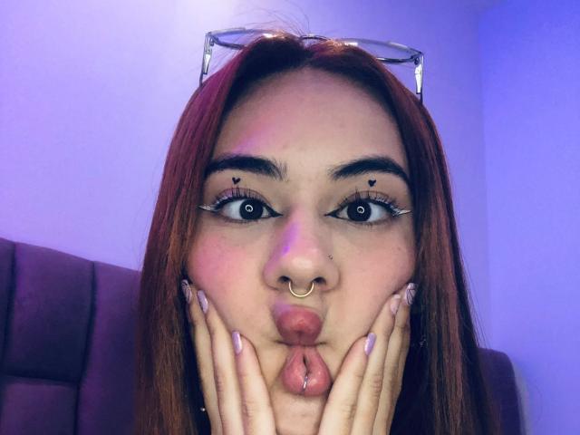 CieloSmith ha i capelli rossi, un piercing al naso e si stringe le labbra con le mani sulle guance. Ha l'eyeliner nero a forma di stella e unghie lunghe e curate..