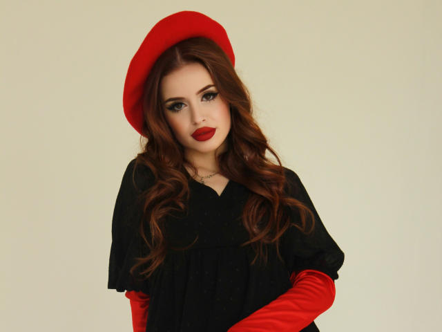 CherylFoxy with red beret, long wavy brown hair, black dress, red velvet gloves, and red lipstick, looking at camera, soft smile, pale skin, cute, sexy.