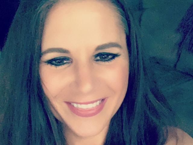 O rosto de SweetYara, sorrindo com lábios rosados, olhos azuis e longos cabelos castanhos. Ela tem um delineador preto marcante, um nariz delicado e um sorriso sedutor..