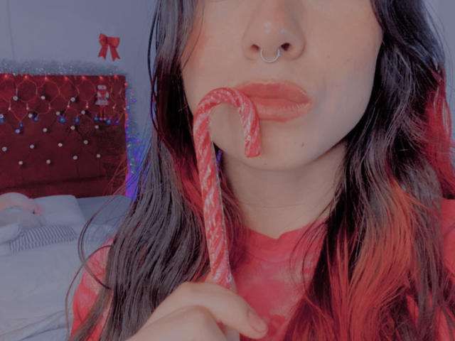 AshleyKatelyn, wearing pink lace bra and white thong, bends over with hand on butt, showing her ass and a glimpse of her pussy. She has a pink cap.