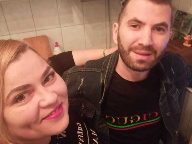 Nikole hat blondes Haar, pinken Lippenstift und ein süßes Lächeln. Jim hat einen Bart, kurze Haare und trägt eine Jeansjacke über einem schwarzen Hemd..