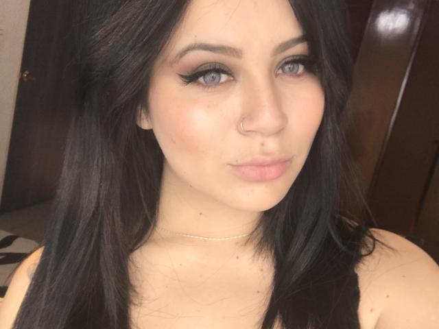 ShantallParis hat eine helle Haut, schwarzes Haar, blaue Augen und einen Nasenring. Sie zieht die Lippen zu einem Schmollmund, trägt schwarzen Eyeliner und eine feine Halskette. Brüste sind sichtbar..