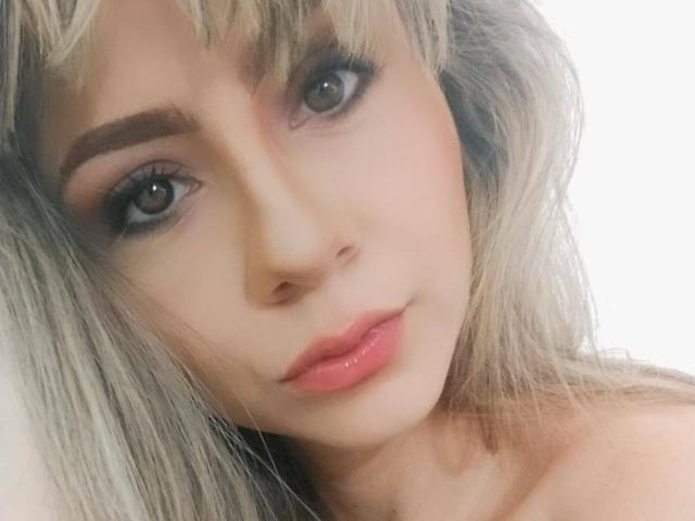 KariCarter has blonde hair, brown eyes, and pink lips with a subtle smile. She's looking at the camera with a cute, sexy face. Her tits are not visible.