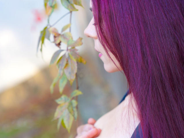 CindeFunRella with purple hair, side profile, touching her small tits with her right hand, leaves in the background, soft light, gentle expression.