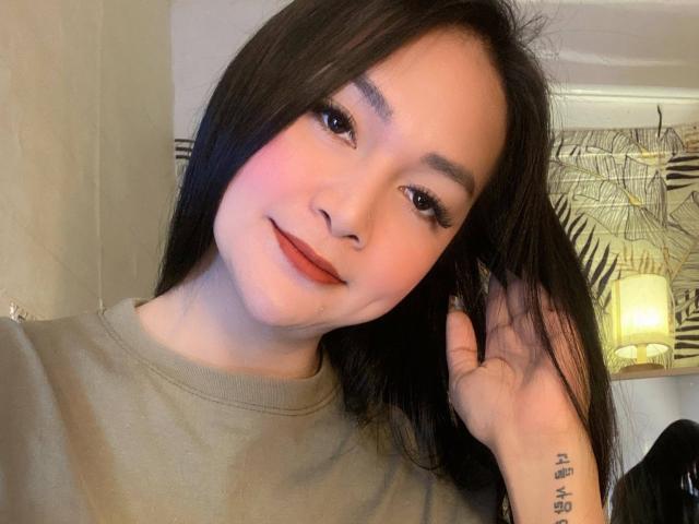 AvirySins heeft een lichte huid, zwart haar en bruine ogen. Ze glimlacht met rode lippenstift, draagt een beige shirt en streelt haar haar. Ze heeft een tatoeage op haar rechterpols..