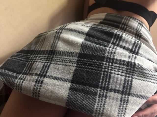 Il sedere di DiLaria in una gonna a quadri, che mostra il suo reggiseno nero e le cosce, con un leggero angolo verso l'alto, che mette in risalto il suo sedere e il tessuto a motivi..