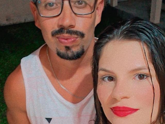 CriseGuh, con barba e occhiali, indossa una canotta bianca, ed è accanto a una donna con rossetto rosso e capelli castani bagnati. Lei ha un viso carino, lui è un bell'uomo..