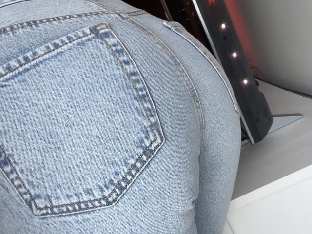 SandraSwweet's tight blue denim butt with a visible back pocket, highlighting her round, textured ass and subtle waistline. Her jeans are slightly worn, showing some fraying.