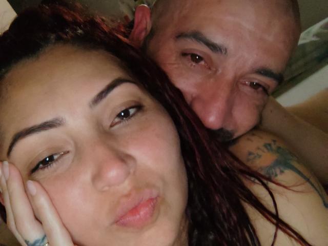 Catelyn tem lábios cheios, olhos castanhos e cabelo tingido de vermelho. Fer é careca, tem barba, uma tatuagem no ombro e o nariz está perto do rosto de Catelyn..