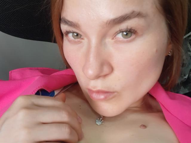 Metztona, met lichtgroene ogen, een roze shirt, en een klein tepel die zichtbaar is, die ze vasthoudt met haar hand, en draagt een ketting met een diamantvormige hanger..