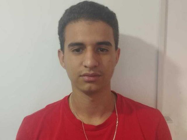 SimonKeler has short black curly hair, brown eyes, and a light brown skin tone. He's wearing a red shirt and a gold necklace, looking straight at the camera.