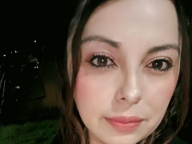 Il viso di Seher è in primo piano, con la pelle chiara, gli occhi marroni e le labbra rosa. Ha i capelli castani ed è leggermente sorridente. Il suo seno non è visibile..