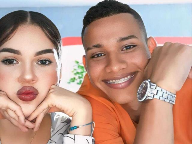 MorenoAndNayla with pouty red lips, hands on cheeks, next to smiling Nayla with short black hair, orange shirt, and silver watch, both looking at camera.