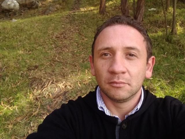 Erick69 has a slightly balding head, short brown hair, and a neutral face with light stubble. He's wearing a black zip-up with a blue striped shirt underneath.