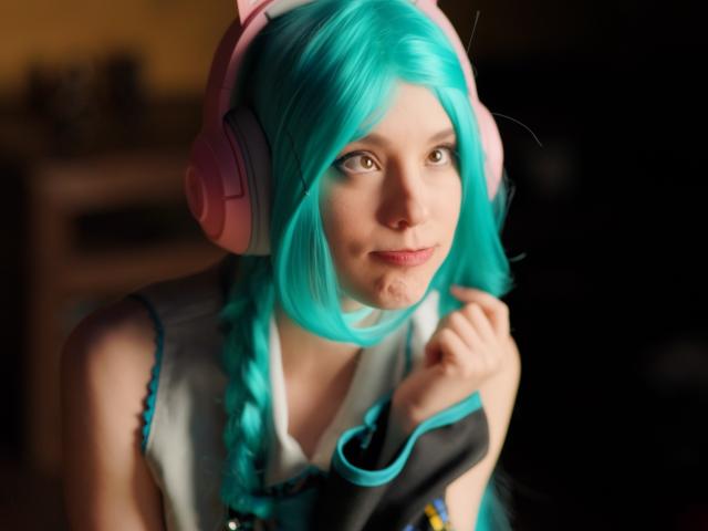 MissAstravert with teal hair, pink headphones, cute smile, holding hair, wearing a sleeveless white top, light skin, looking to the side, soft lighting, blurry background.
