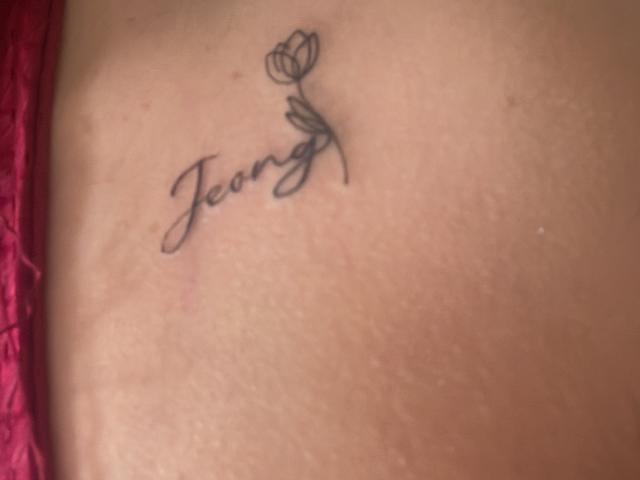 ShannelTaylor's ass has a small black tattoo of a flower with the word "Jeong" in cursive above it. Red lace is on the left side of the image.
