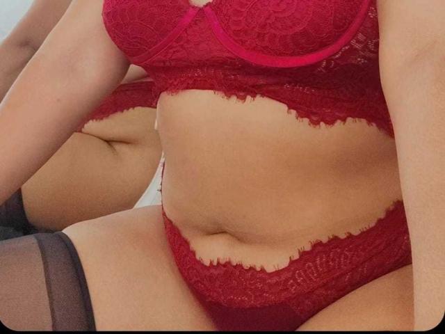 EvaMadison in red lace lingerie, showing her tits and pussy in the bra, and her ass in the panties, with black thigh-highs, reflecting in a mirror.