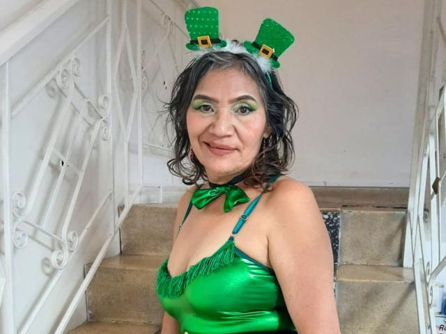 CelesteBakers tem olhos verdes, veste um vestido verde brilhante com bordas franjadas, uma faixa de cabeça verde com orelhas de trevo verde e dourado, e um laço verde. Seus seios são pequenos..