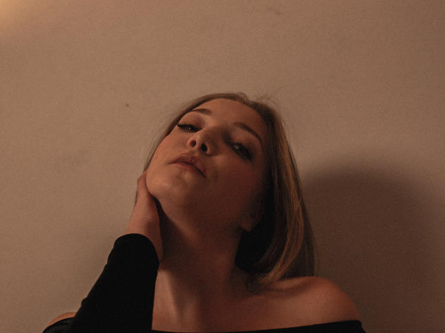 A close-up of a flat, three-dimensional sculpture featuring four large, overlapping letter "L" shapes in a muted brown. Simple, geometric design with subtle shadowing. Clean, minimalist style.