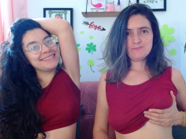 LunaVenus with long black hair and glasses, smiling with arm raised, wearing a red crop top. LunaVenus with gray hair, covering her tits with hand, serious expression.