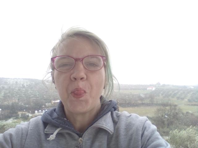 CuteDebby-hot with puffy pink glasses, pouty lips, blonde-green hair, and gray hoodie, looking goofy. Her ass is not visible. Her tits are small and not noticeable.