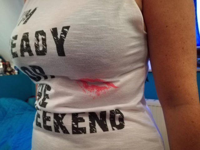 XXHotAngelinaXX-sex's white tank top showing her large, tight, and slightly sagging tits with a red kiss mark, and her tan, freckled arm.