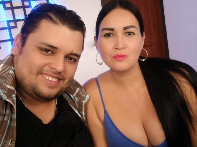 SalomeAndJhosep have a selfie with Salome's big tits in a blue dress and Jhosep's plaid shirt, both smiling. Salome has long black hair and hoop earrings.