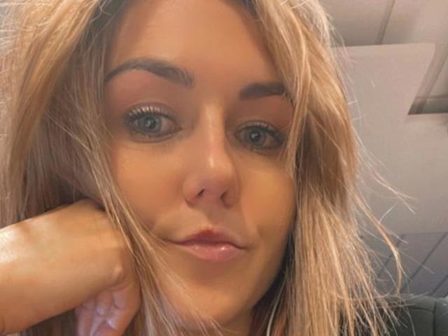GanzNettePaola-hot hat blondes Haar, volle Augenbrauen und hält ihr Kinn mit der Hand, wobei sie ein leichtes Lächeln zeigt. Sie hat blaue Augen und glänzende, rosafarbene Lippen..