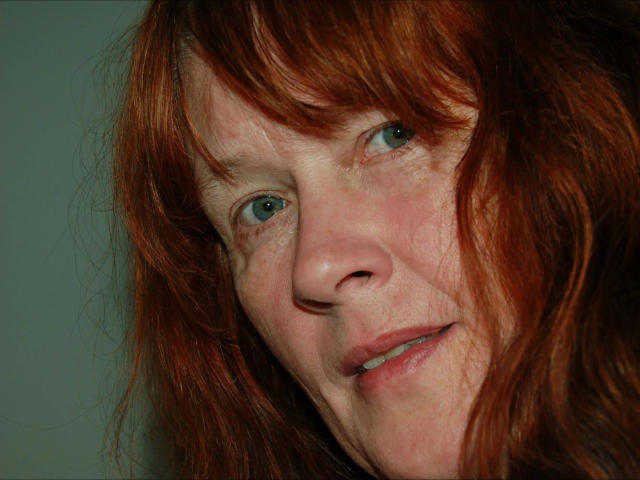 Johannalive-hot a les cheveux roux et en bataille, les yeux verts, et un léger sourire. On peut voir quelques rides et quelques taches de rousseur sur sa peau claire. Son nez est petit et elle est mignonne..