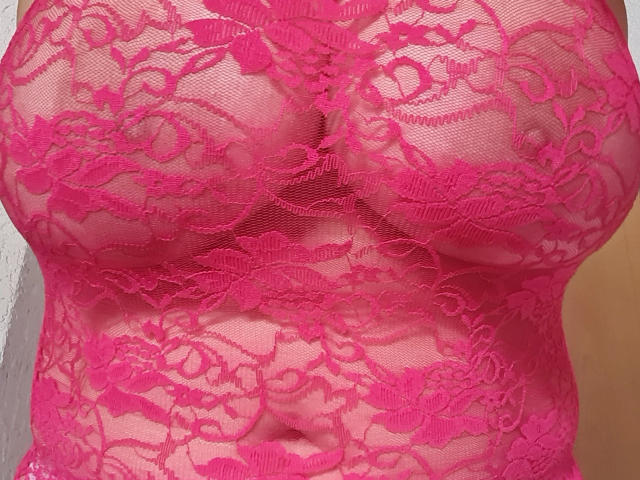 Lady-Mercedes' pink lace lingerie, showing her tits and a hint of her pussy, with intricate floral patterns covering her chest and midsection. Her skin is visible through lace.