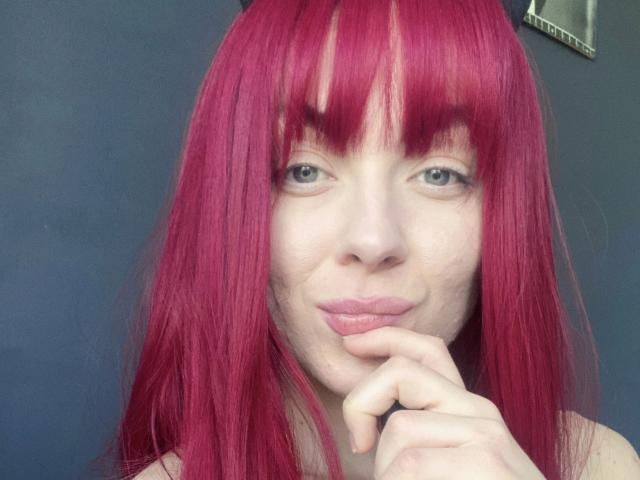 Jessie: Capelli rosso fuoco, pelle chiara e occhi verdi, labbra rosa leggermente arricciate, che tocca il mento con un dito. Ha la frangia dritta e indossa una maglietta nera..