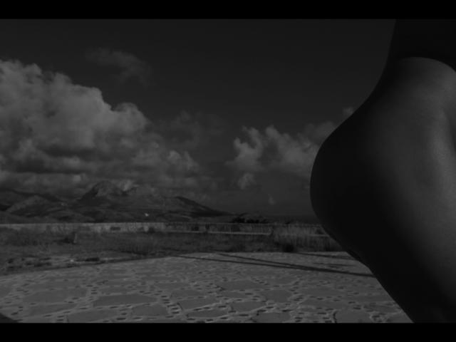Lulu-4-you's ass in the right foreground, black and white, with a mountain landscape and cloudy sky in the background, showing textured ground patterns.