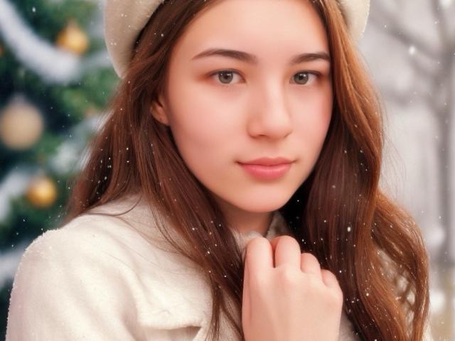 UBabyGilly has long brown hair, wearing a white fuzzy hat and coat, with soft snow falling. UBabyGilly's cute face, light pink lips, and gentle smile are in focus.