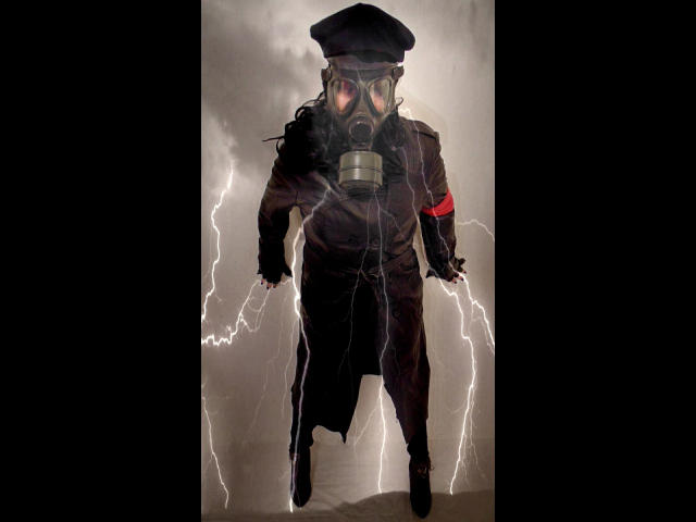 KatarinaArsch-hot stands in front of lightning, wearing a gas mask, black hat, and brown coat with red armband, looking fierce with glowing eyes and smoke around.