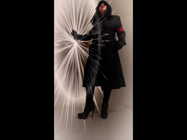 KatarinaArsch-hot stands in black high heels, black coat, and gloves, with a red armband, touching a sparkling white burst of light, showing her black boots and ass.