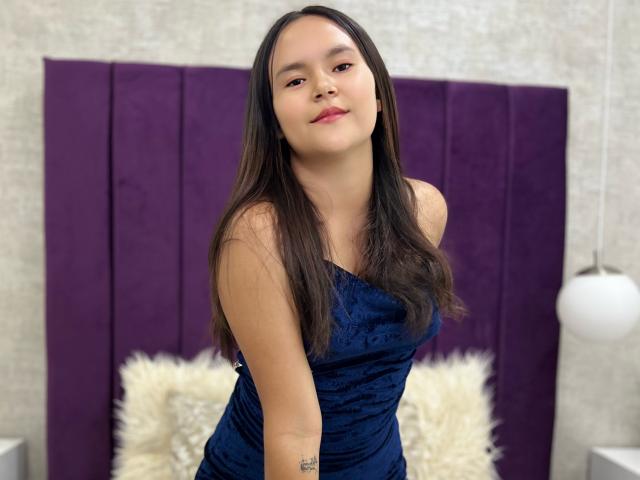 Digital illustration of a minimalist, stylized coat of arms with a bold, red "R" in the center. Soft pink and white background. Simple, clean lines. No additional elements.