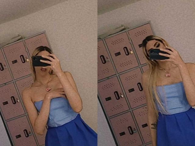 Putinna with long blonde hair, strapless blue top, and high-waisted blue skirt, covering her tits with one hand, taking a mirror selfie, wearing a pink necklace.