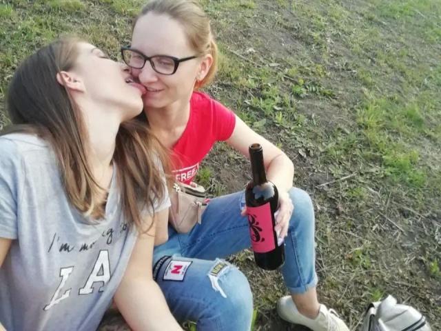 DoubleloveXXX-hot with glasses kissing DoubleloveXXX-hot's tongue out, holding a beer bottle. DoubleloveXXX-hot in red shirt, DoubleloveXXX-hot in grey shirt, jeans, and white sneakers.