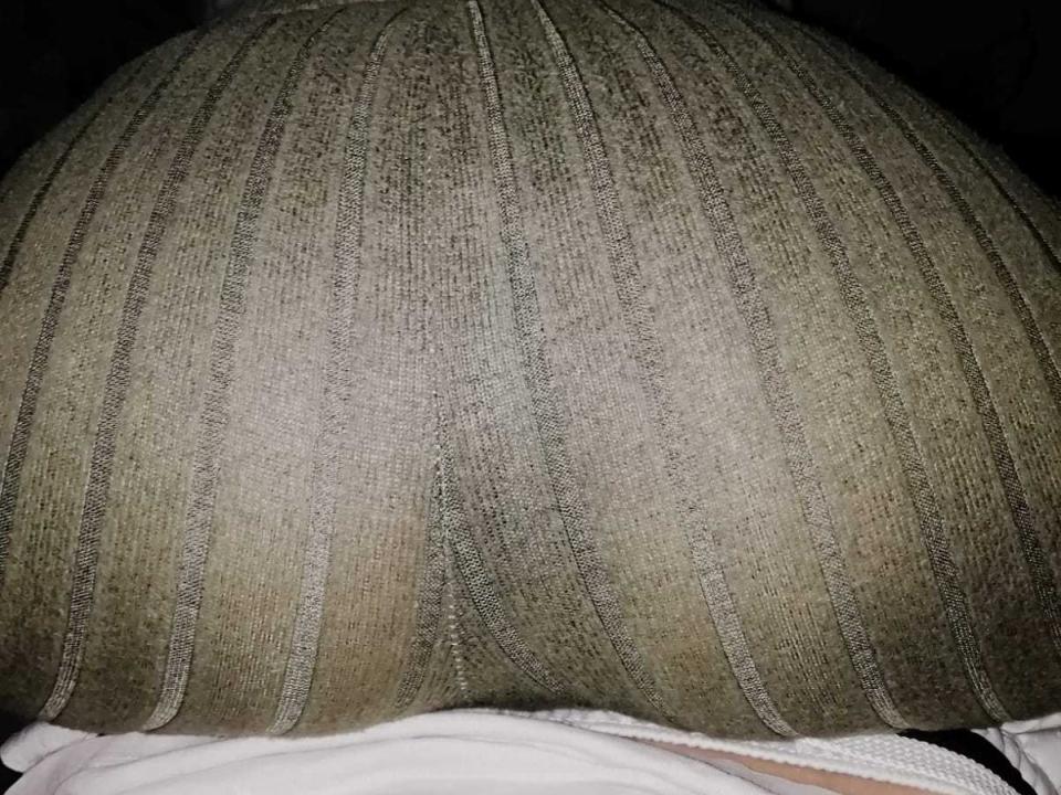 Chichiy's big ass, covered in a green, textured fabric with vertical lines, is centered in the photo, showing a slight white garment at the bottom.