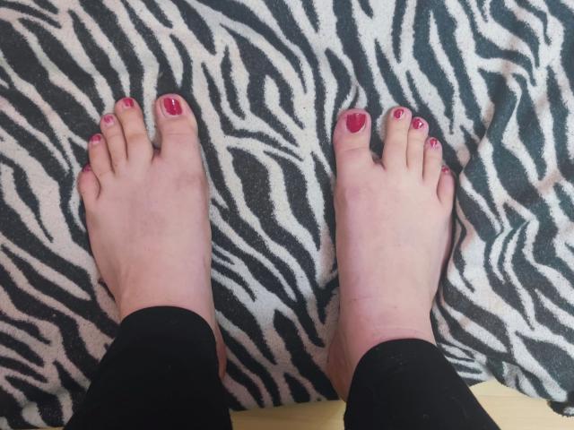 ChubbyBubby-hot's feet with pink toenail polish, white skin, black socks, and zebra-patterned blanket underneath.