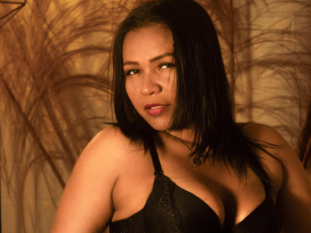 LouiseNails with brown skin and straight black hair, wearing a black bra, pouty lips, looking to the side, small boobs, brown eyes, and a subtle nose ring.