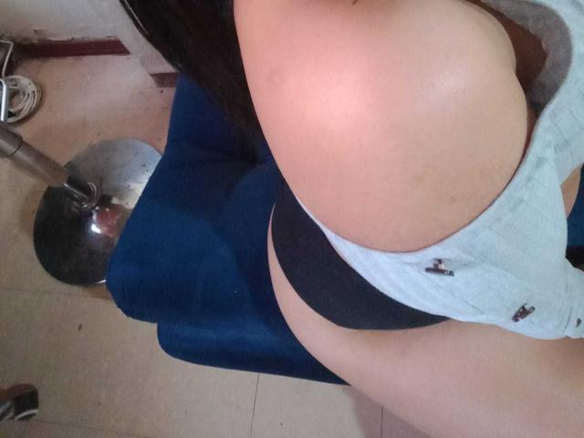 AmyWhin's large ass in black panties, with a gray top pulled down to expose her tan skin and her black hair falling over her shoulder. Top-down angle.