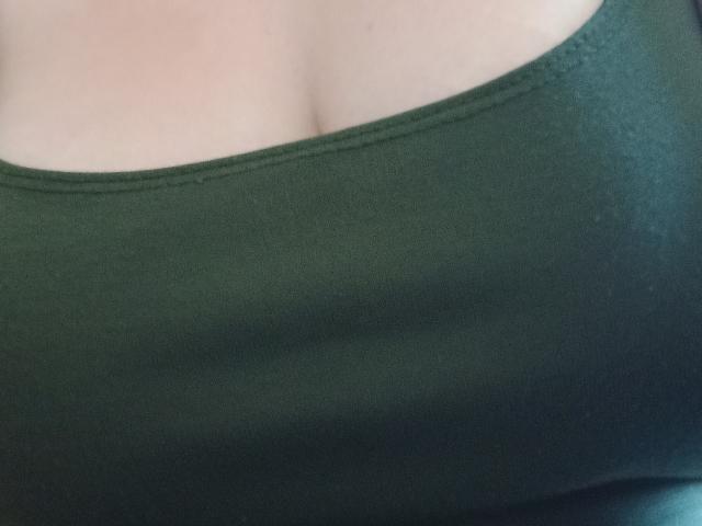 DiLaria's green tank top is showing a lot of her big, round, soft tits with a slight cleavage. The fabric is tight and smooth.