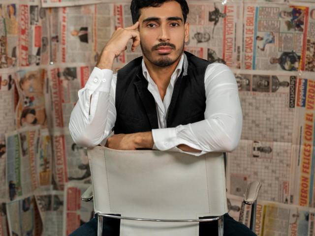 A bold, flat illustration of a large, red-stamped letter "V" with a white, partially-filled letter "V" below. Simple, solid colors with a strong, graphic design style.