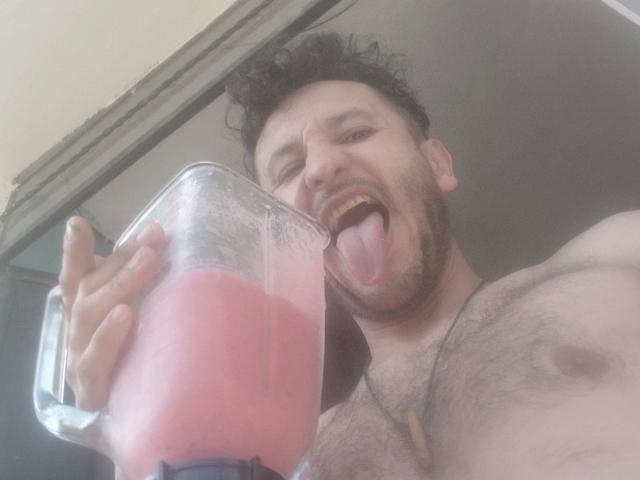 davydwolf-hot with messy dark hair, beard, and chest hair, sticking out tongue, holding pink milkshake, shirtless, necklace, and looking at camera.