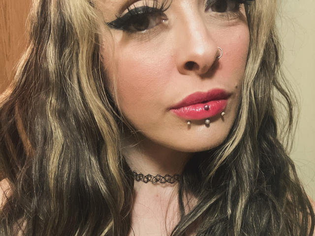 Harley Quinn heeft golvend blond en bruin haar, dikke zwarte eyeliner, roze lippenstift, een neusring en een piercing aan de onderlip met twee zilveren bolletjes. Ze draagt een zwarte choker..