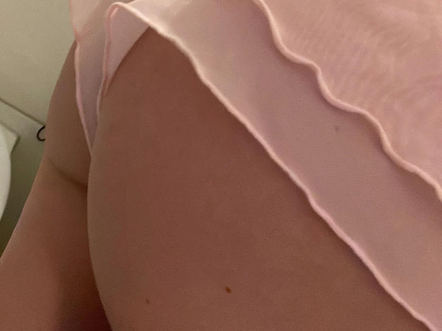 XxxLenaLustxxX-hot's ass in pink ruffled underwear, showing a small mole on her right buttock, with a close-up angle emphasizing her curved, pale skin.